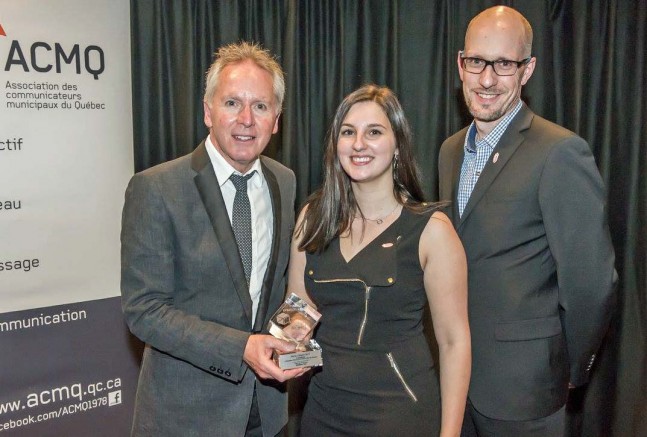 Louis Latraverse, président de l'AMCQ et responsable des communications pour la Ville de Sorel-Tracy qui remet le prix à Josiane Cyr, responsable des communications et Frédérick Marceau, coordonnateur à l’environnement et au développement durable à la Ville de Prévost. Photo: courtoisie